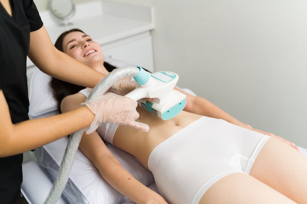 Radio frequency. Cheerful young lady receiving a new body treatment at the beauty clinic