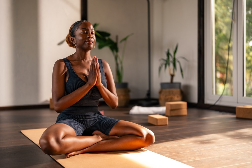 Young black woman practicing yoga indoors